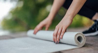 Closeup of yoga mat, being rolled after a complete workout.